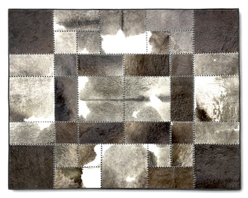 A square patchwork rug made of irregular cowhide-style panels in mixed gray, taupe, brown, and off-white tones, stitched together with a dark border.