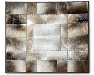 A square patchwork wall art piece made of stitched leather or faux-leather panels in metallic silver, bronze, and brown tones, shown against a plain white background.