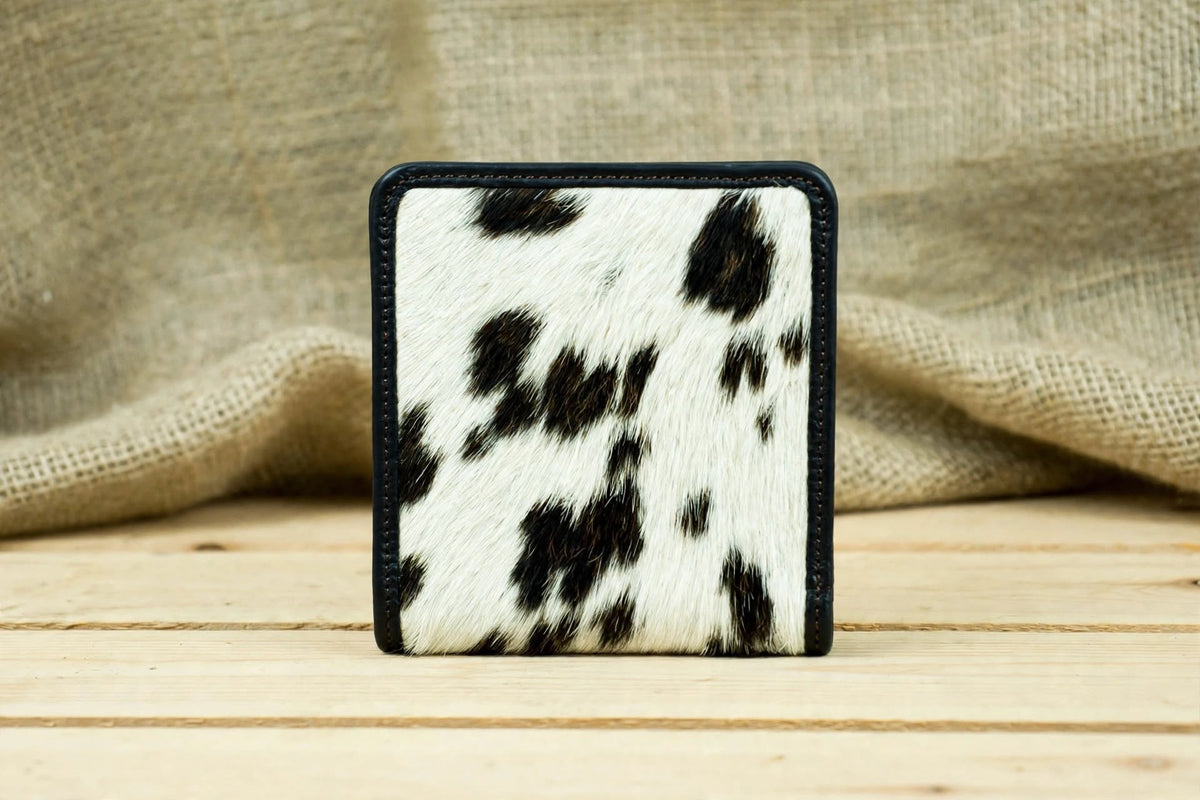 1. Front View: Genuine leather cowhide bifold wallet with natural black and white hide pattern and black leather edging.